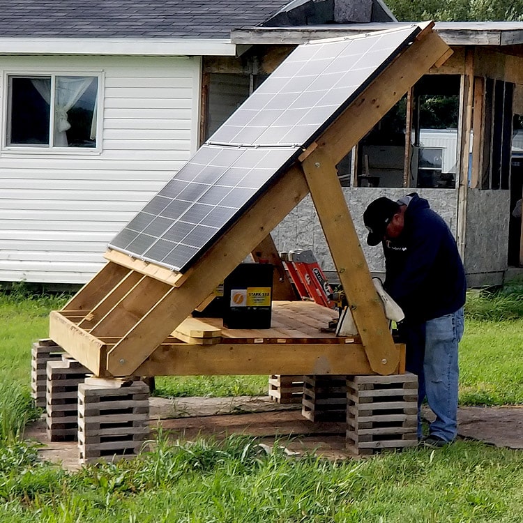 Worker bringing solar power to a remote cabin location